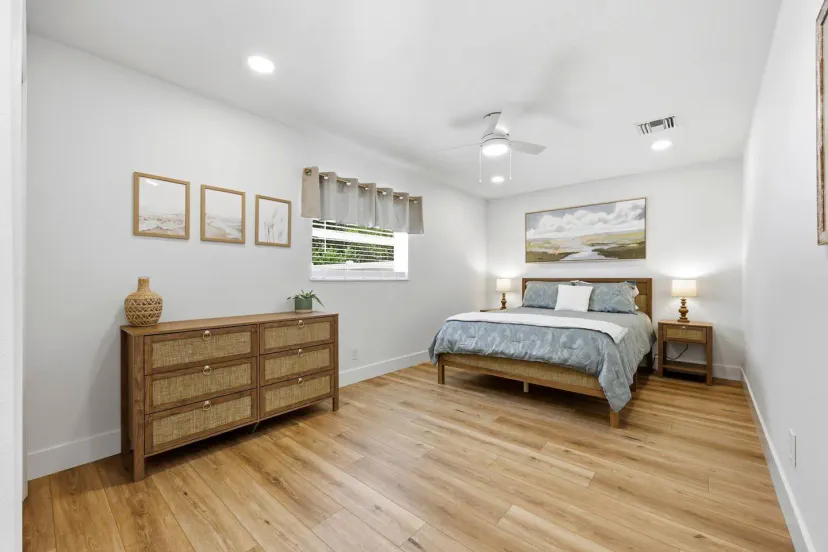 Suite tranquila con cama queen y cálidos pisos de madera y espacio para ropa.