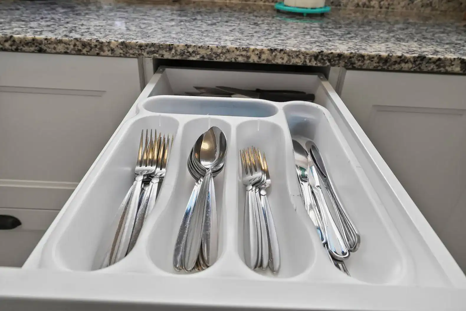 Cutlery drawer with neatly arranged forks, spoons, and knives