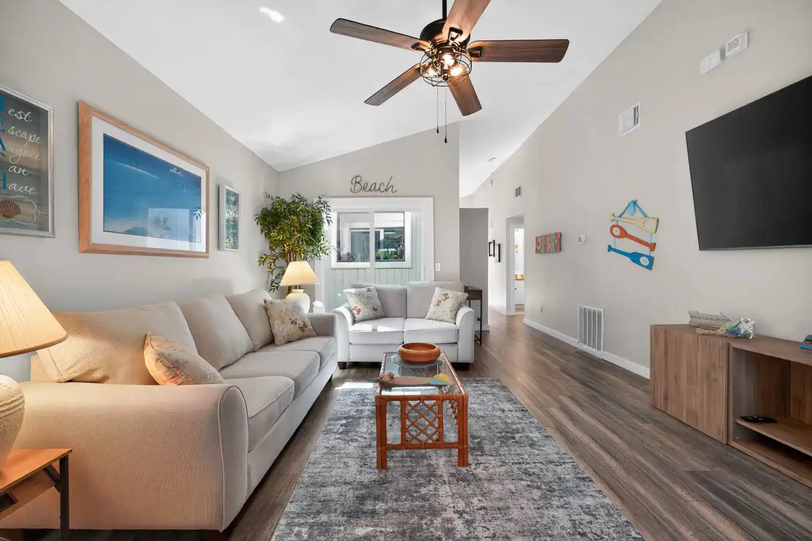 Bright and airy living room with comfortable seating and beach-themed decor
