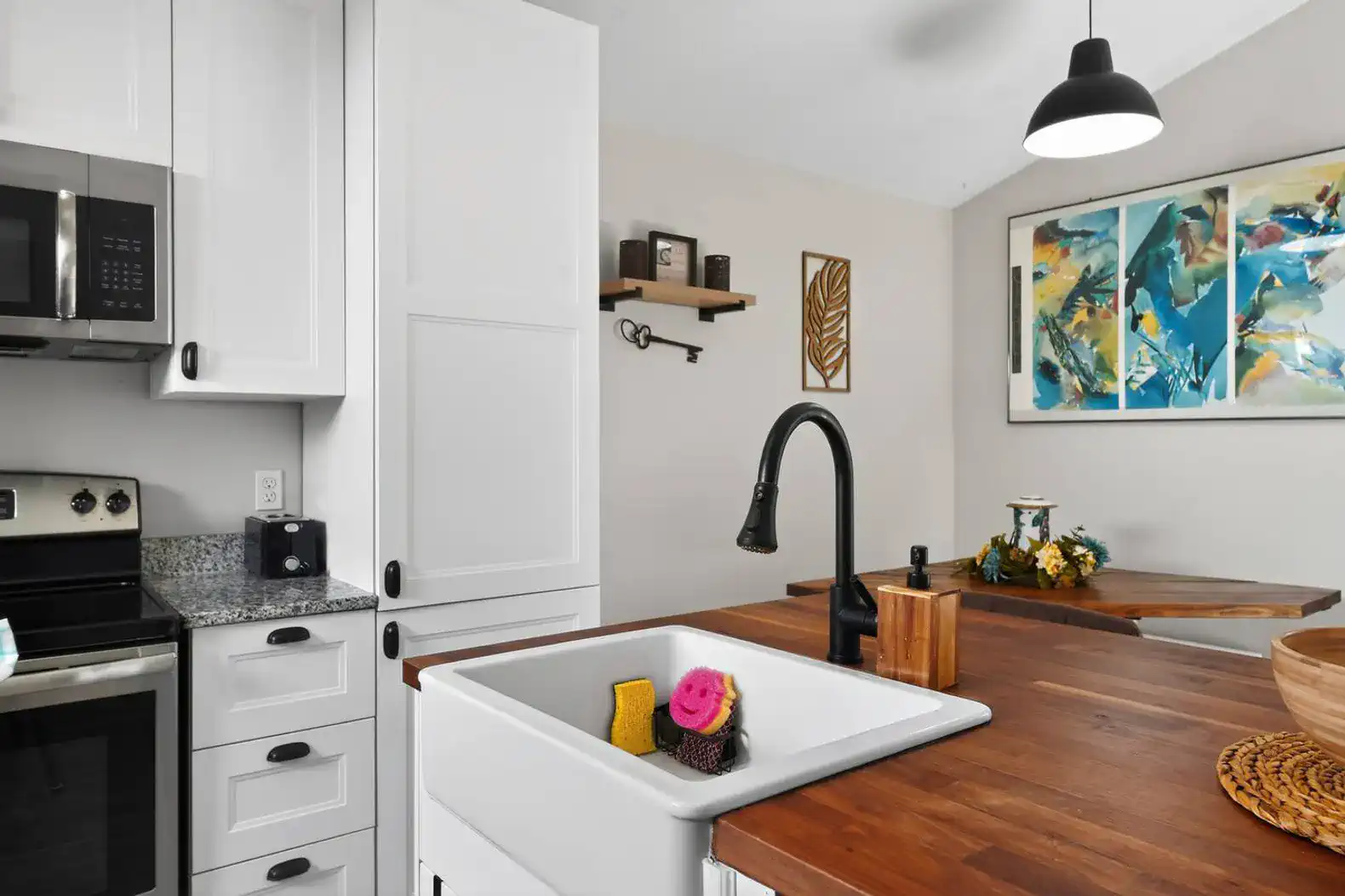 Modern kitchen with white cabinets, granite countertops, and a stylish sink