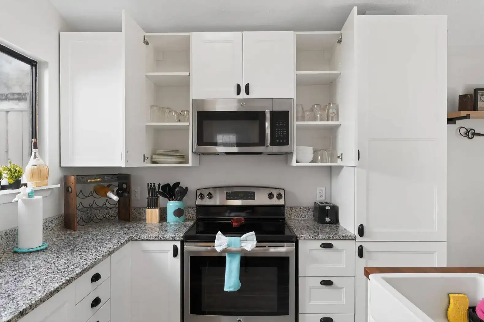 Modern kitchen with white cabinets, granite countertops, and stainless steel appliances