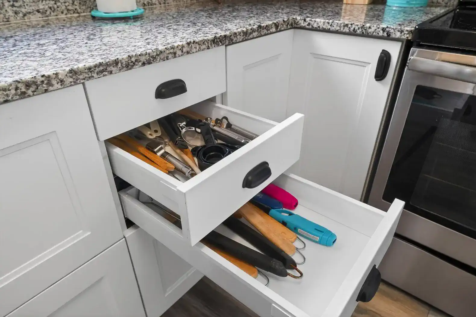 Kitchen drawers filled with various cooking utensils and tools