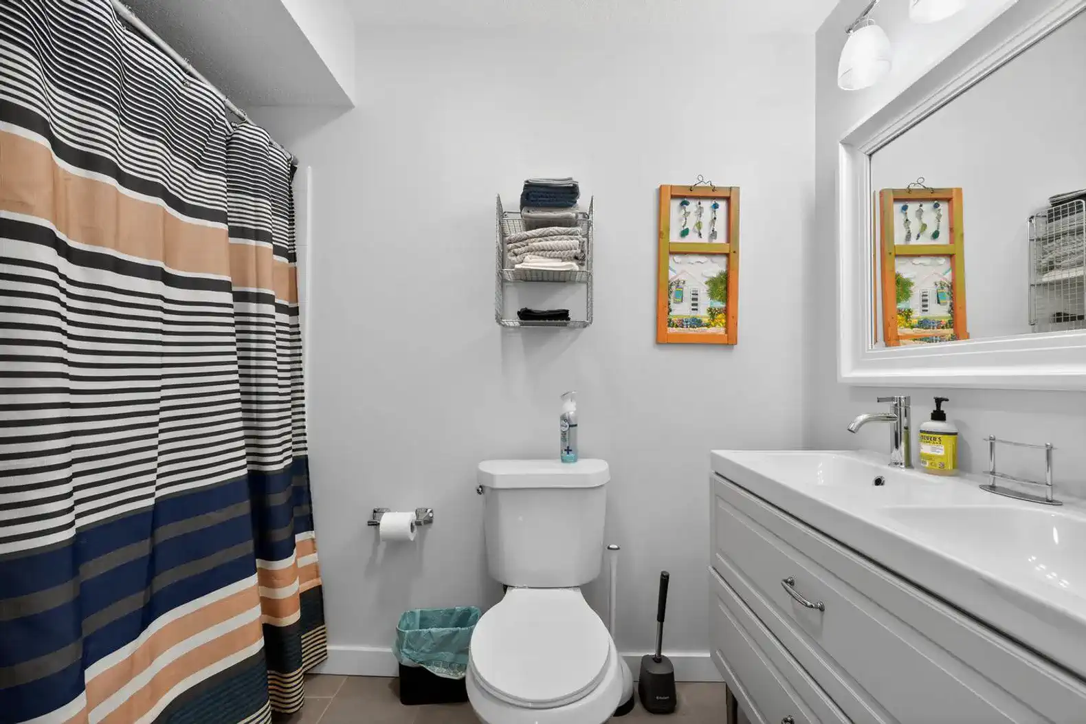 Modern bathroom with striped shower curtain and sleek vanity