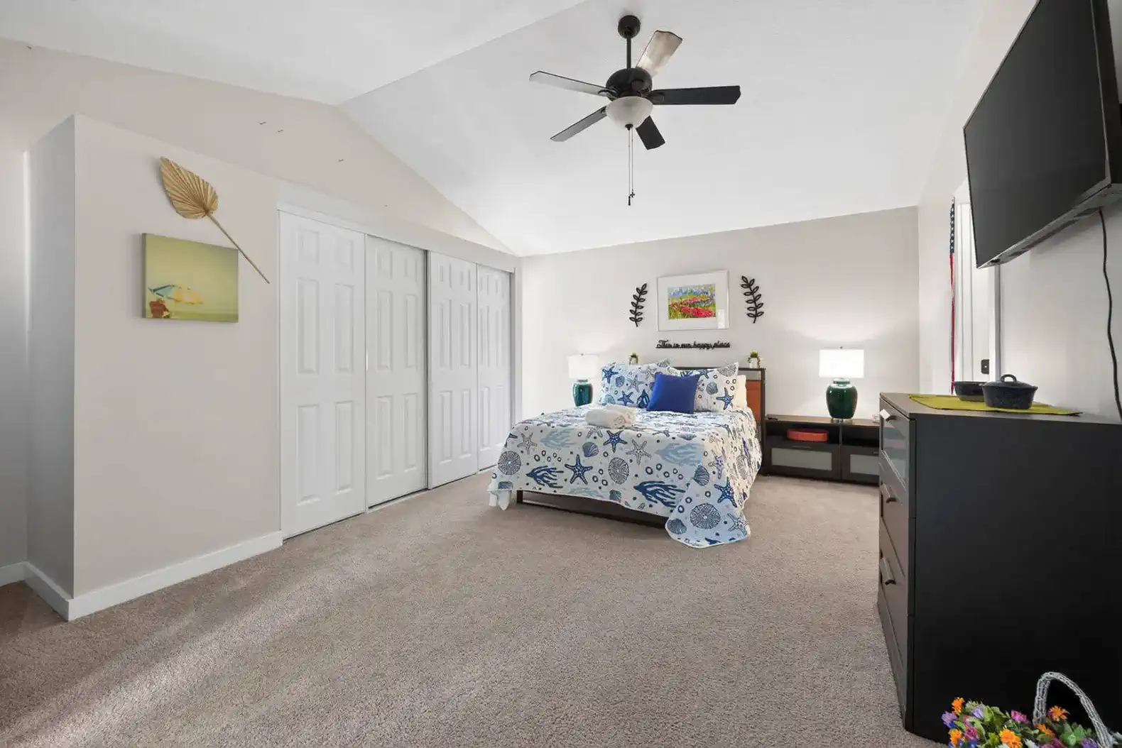 Cozy guest bedroom with a ceiling fan and ample storage space