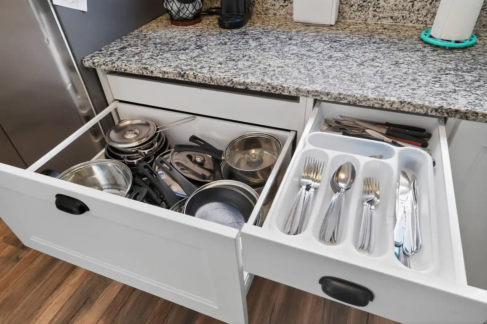 Organized kitchen drawers with pots, pans, and utensils