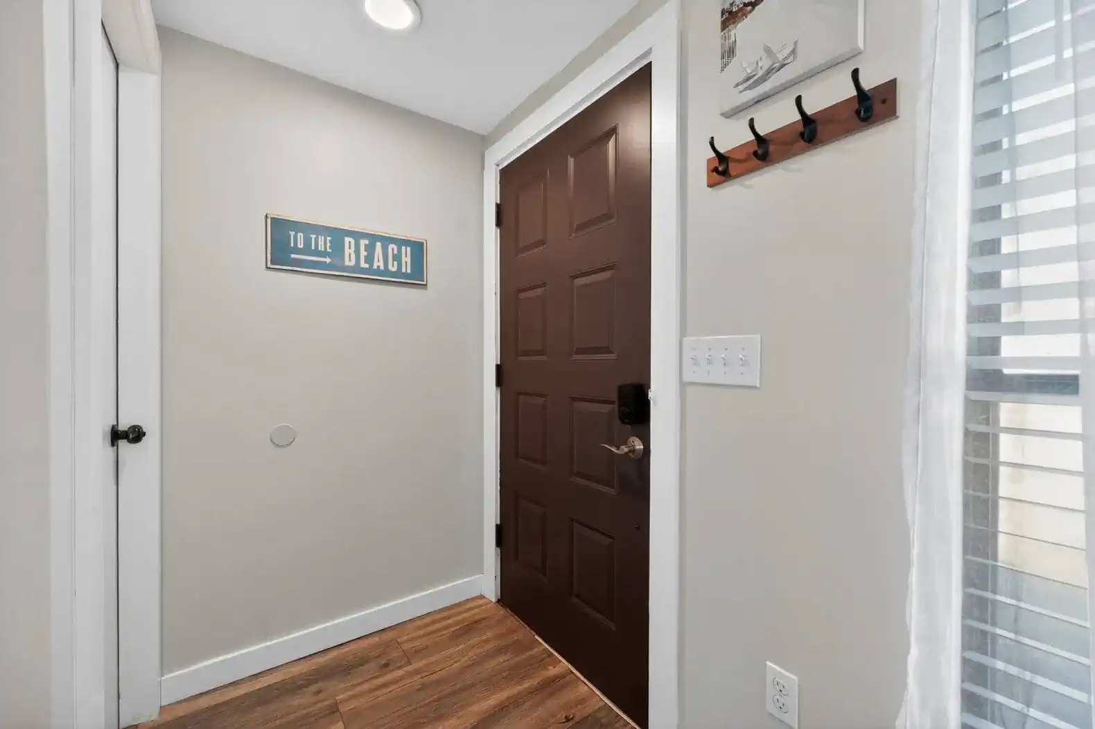 Welcoming entrance with beach-themed decor and wooden flooring