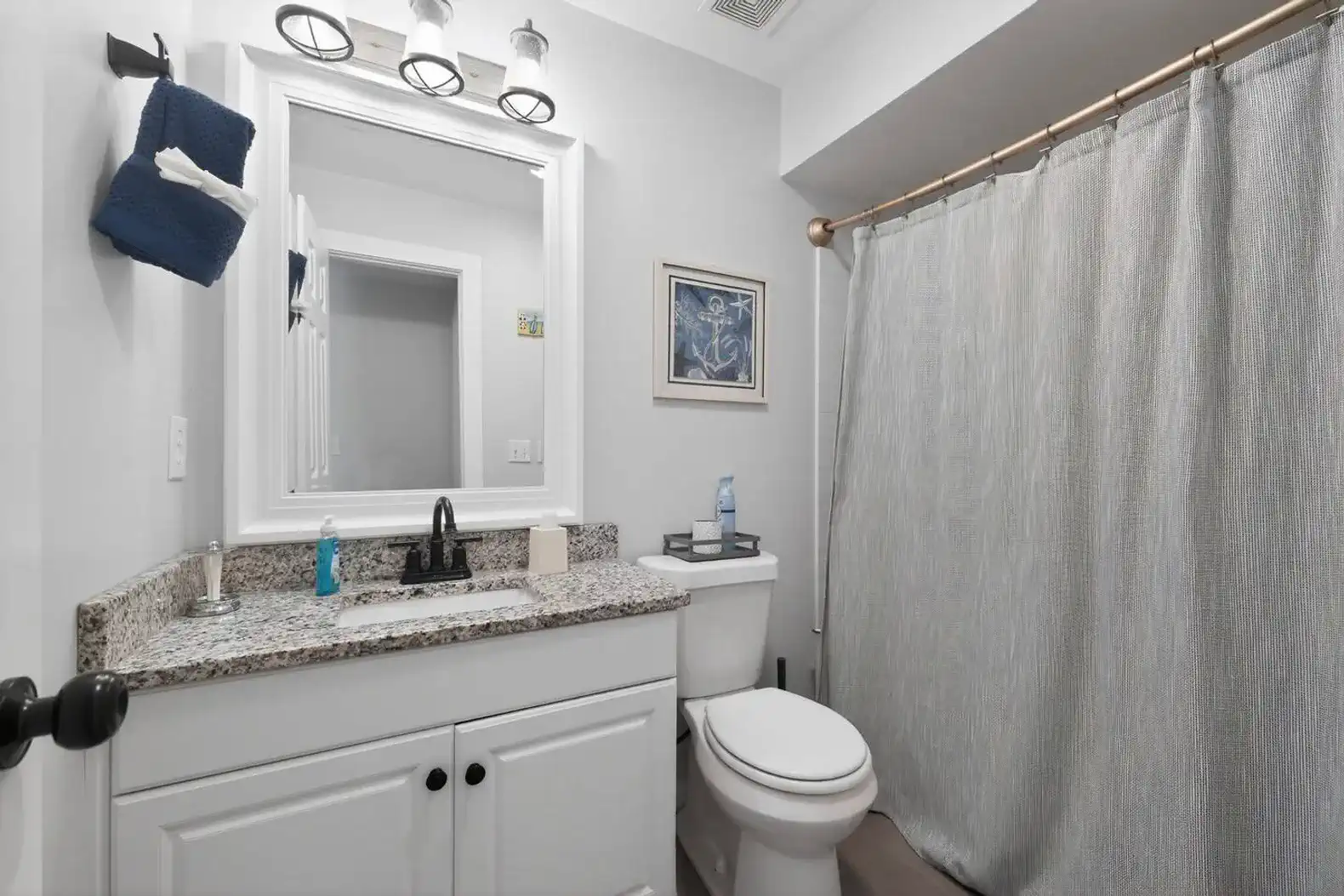 Modern bathroom with granite countertop and shower curtain
