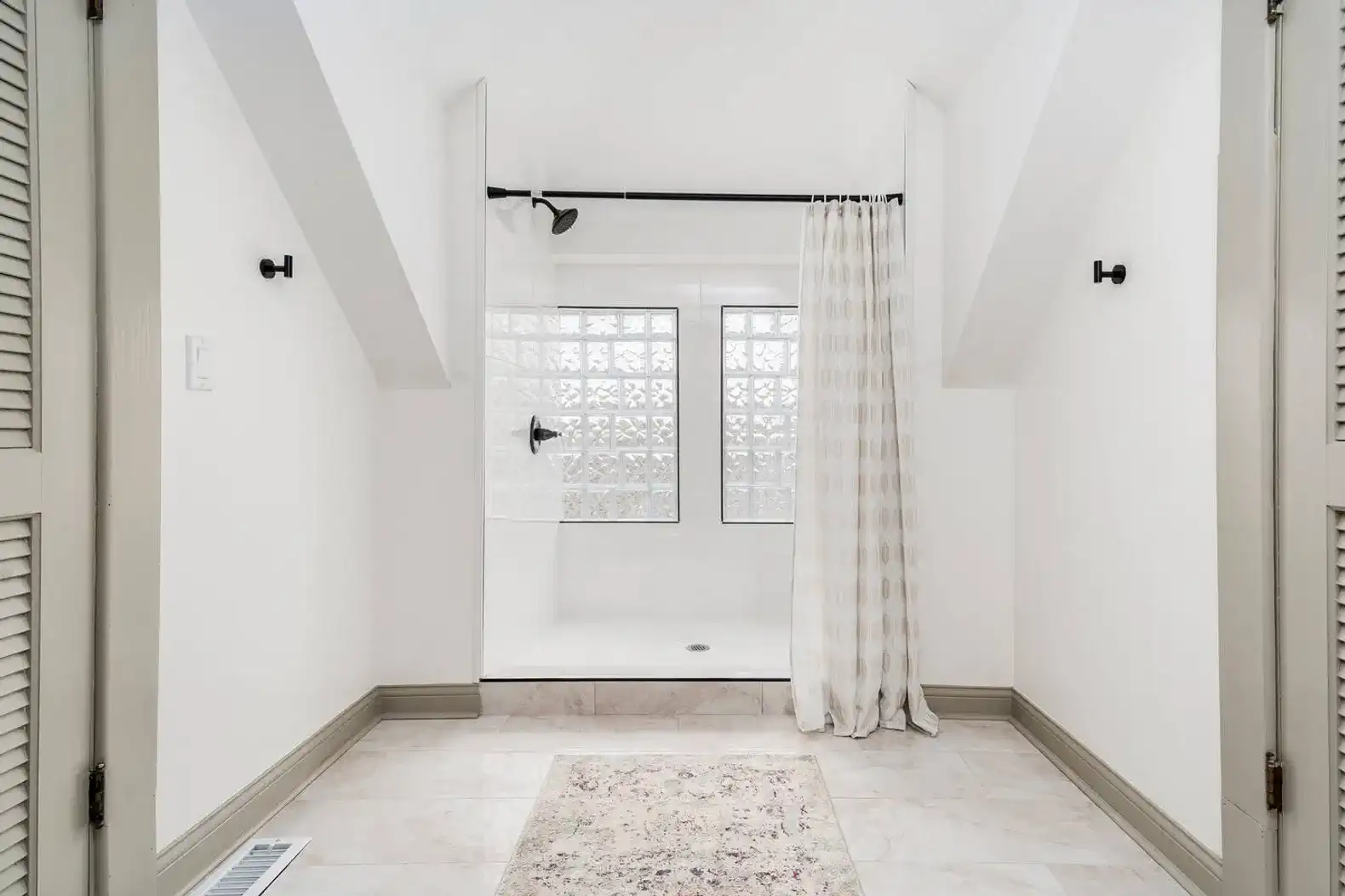 The primary bathroom offers a sun-filled standing shower and a separate toilet room.