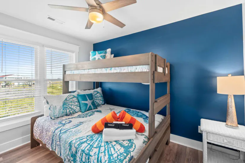 Cozy bunk room with blue accent wall and nautical decor