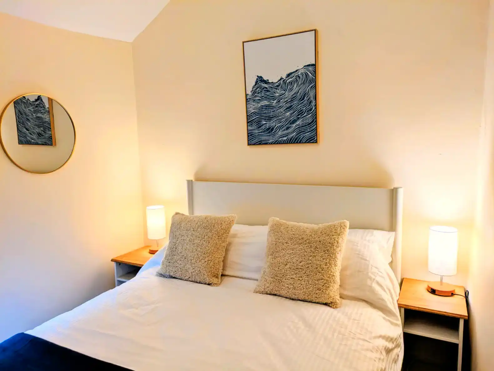 Cozy bedroom with a double bed, soft pillows, and decorative wall art
