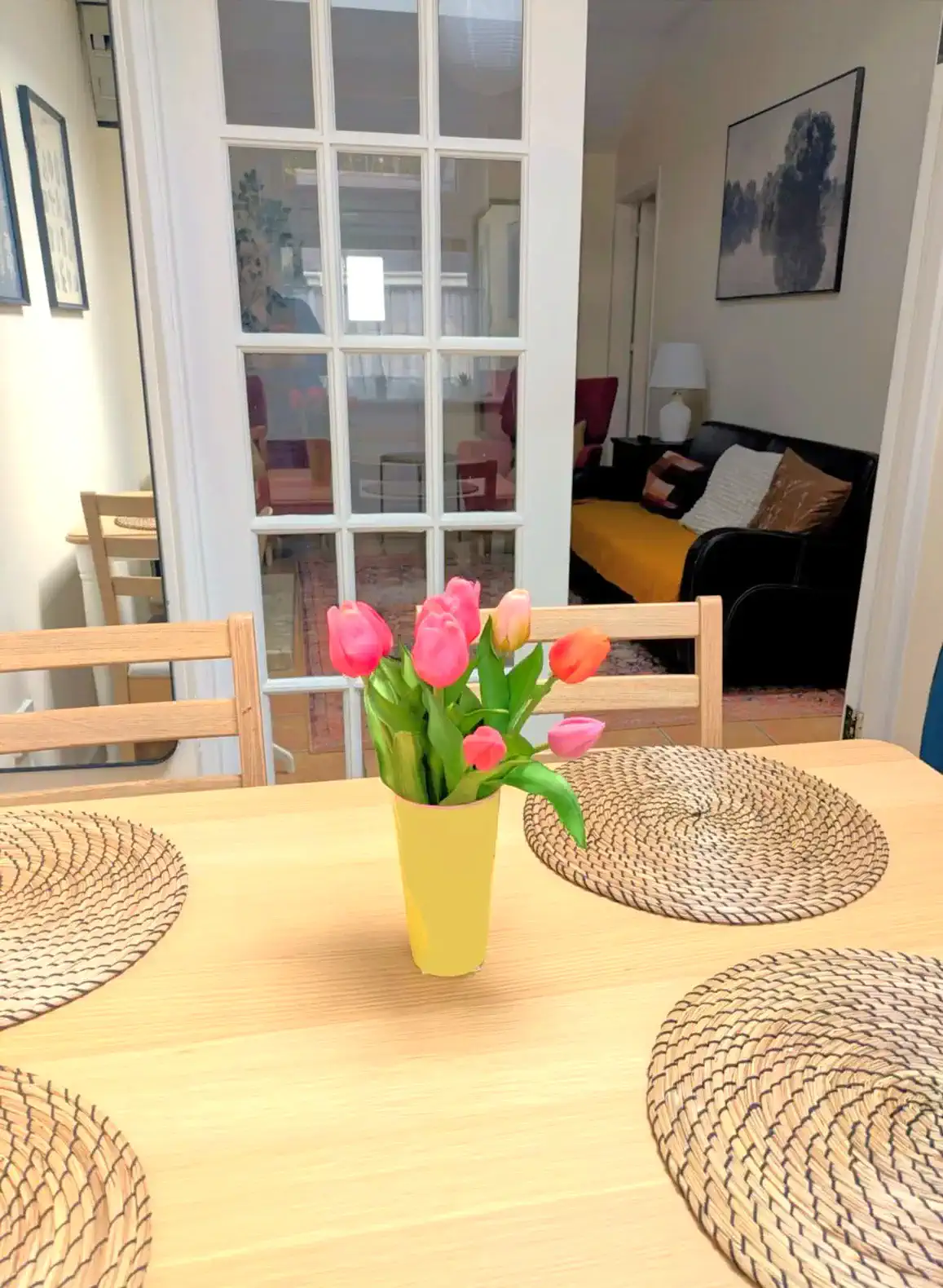 Dining table with tulips and woven placemats in a cozy cottage setting