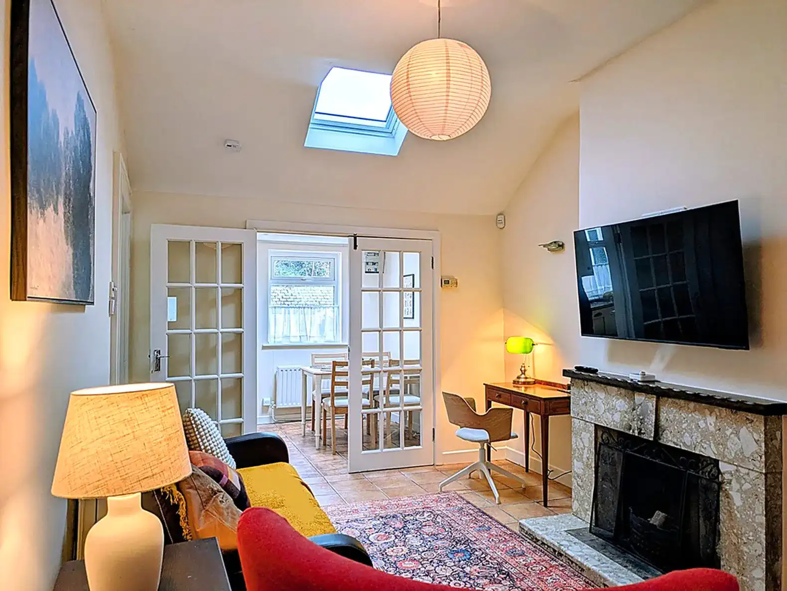 Cozy living area with a fireplace and a view of the dining space