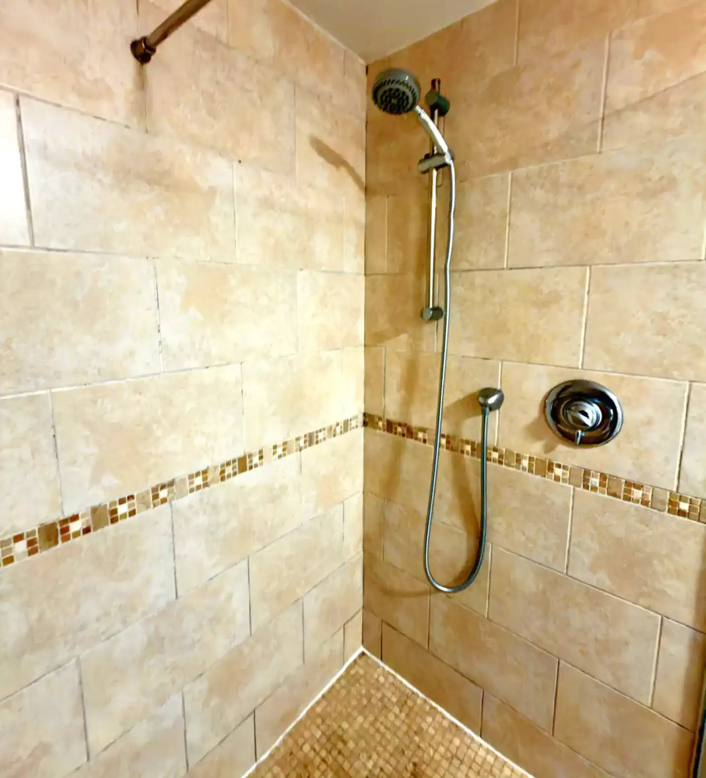 Spacious shower with tiled walls and modern fixtures