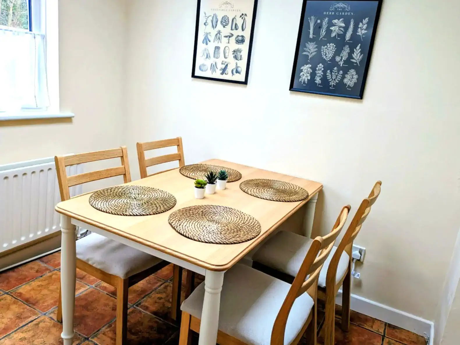 Cozy dining area with a wooden table and four chairs, adorned with placemats and decorative plants