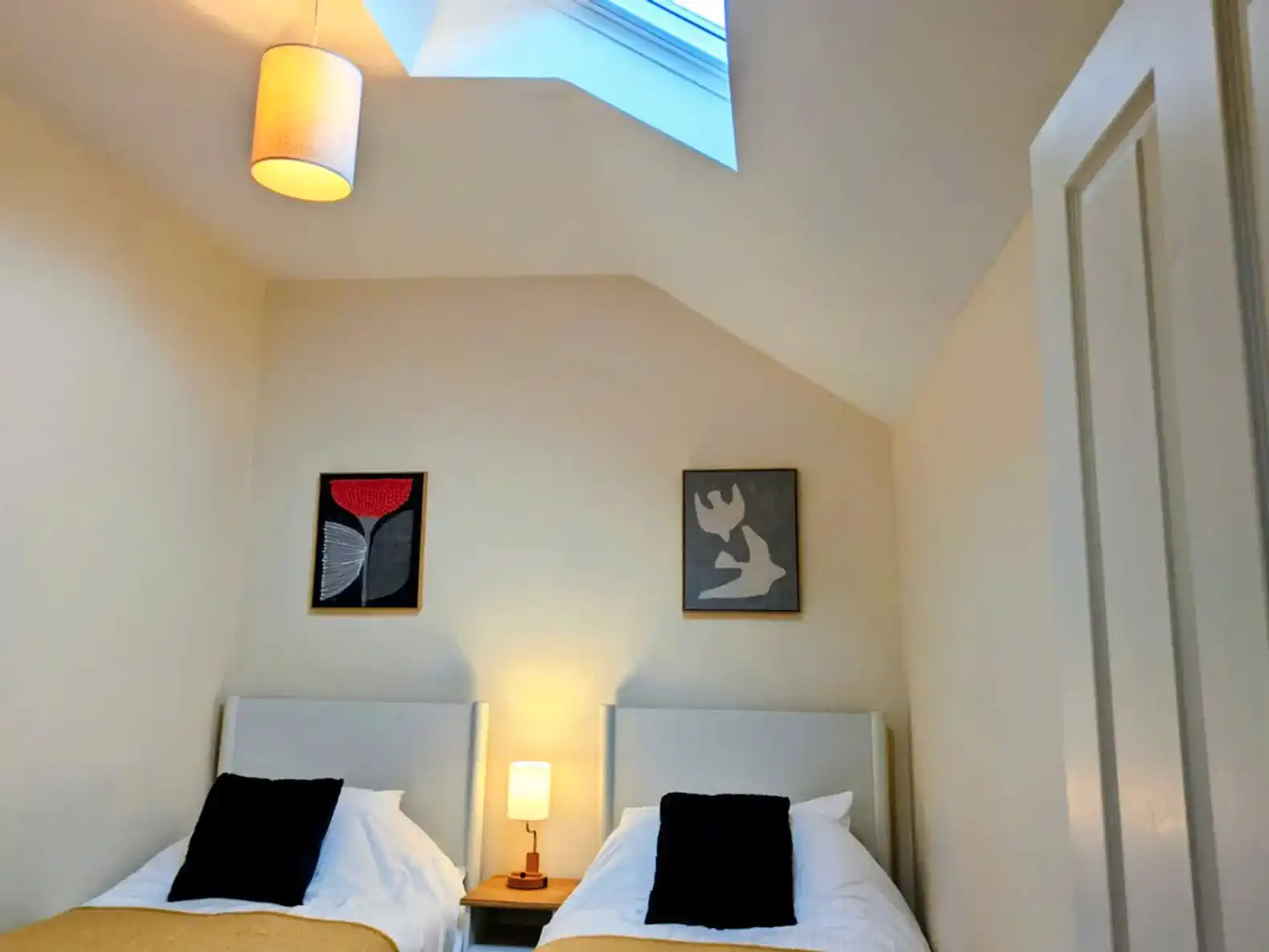 Cozy guest bedroom with twin beds and skylight