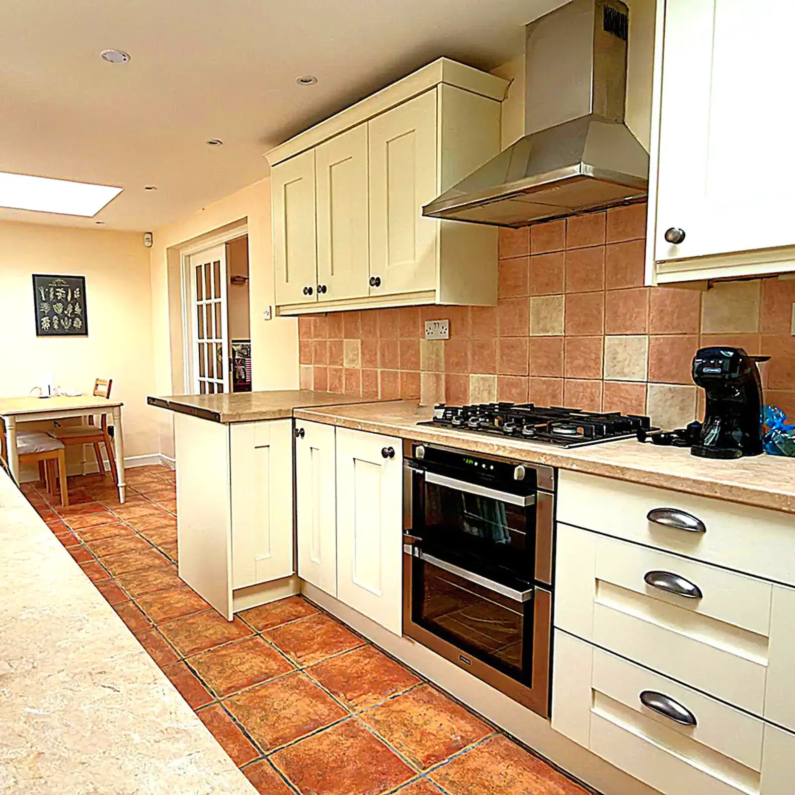Modern kitchen with cream cabinets, gas stove, and tiled floor