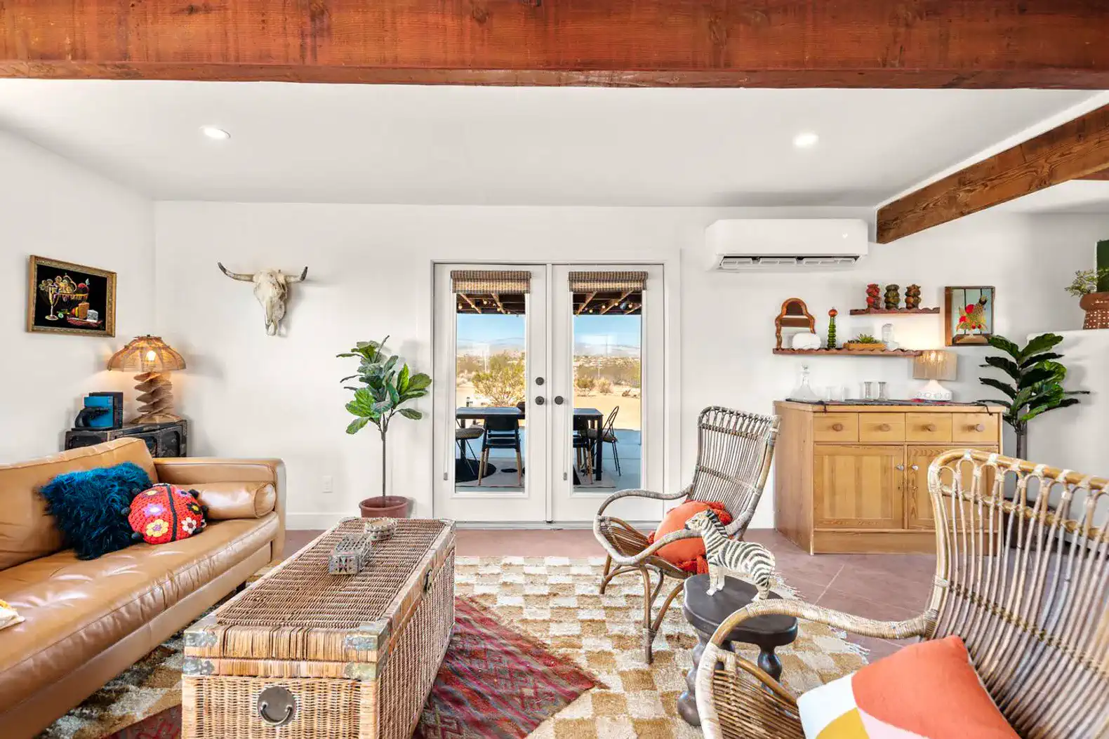 Cozy living room with leather sofa, decorative accents, and double doors leading to outdoor space
