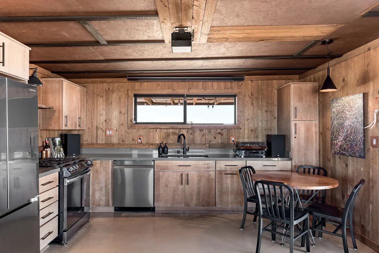 Modern kitchen with wooden cabinetry, stainless steel appliances, and a round dining table