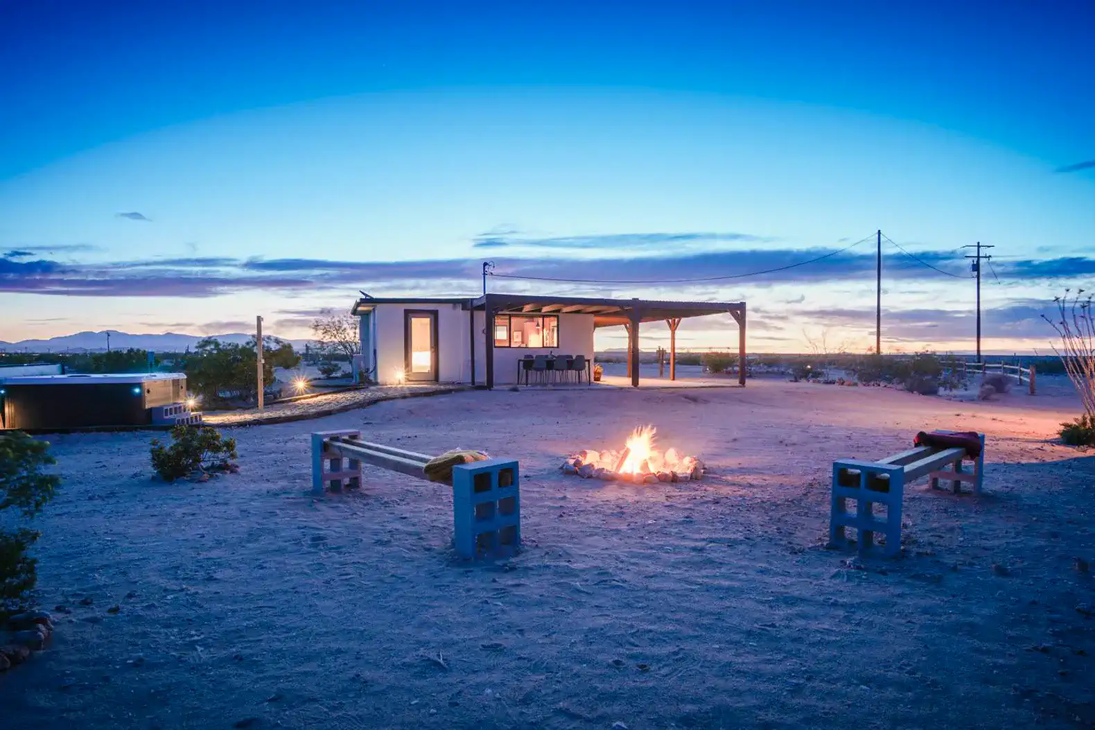 Outdoor area with a fire pit and seating under a twilight sky