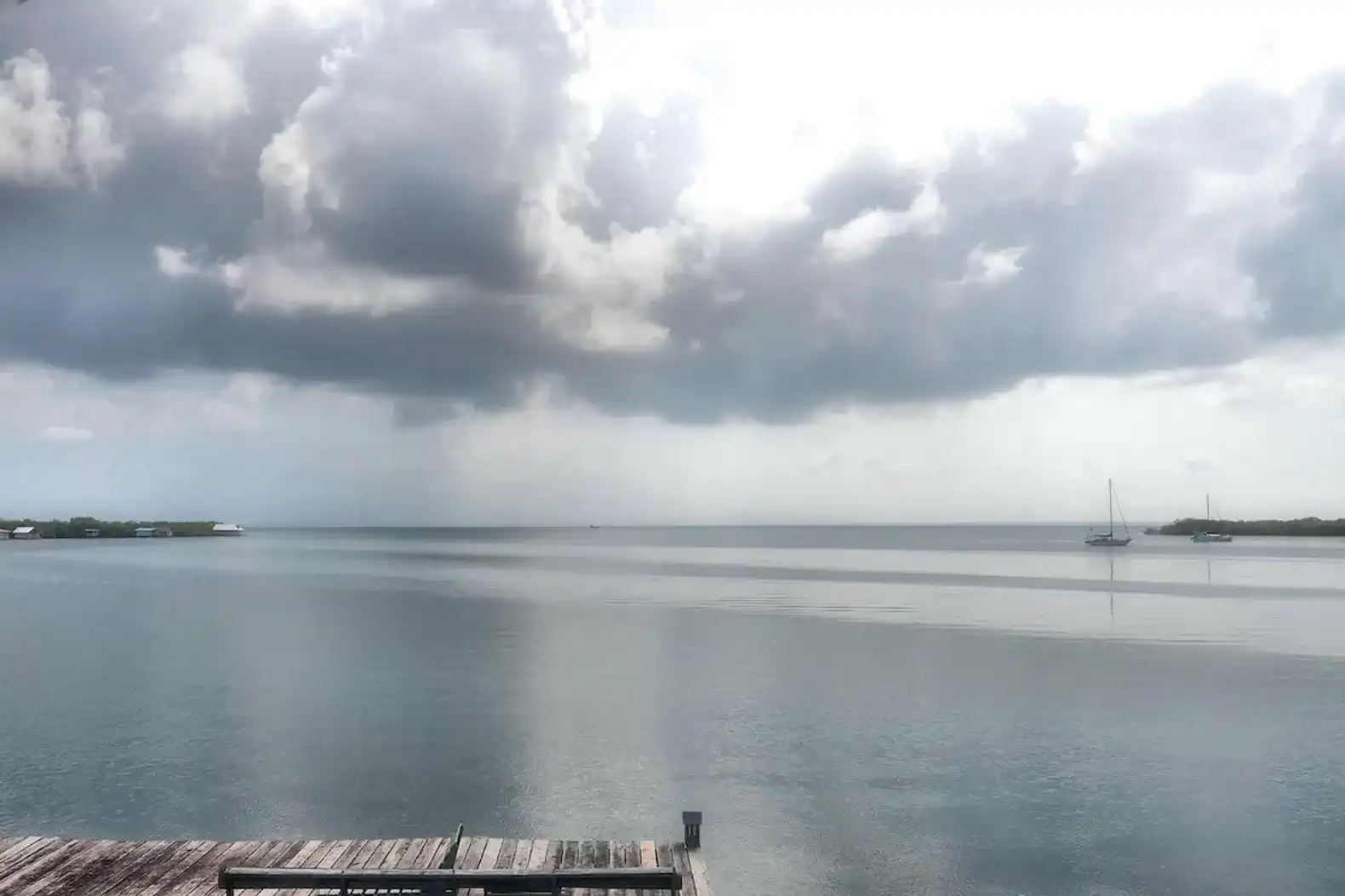 Serene view of Saigon Bay with calm waters and distant boats under cloudy skies