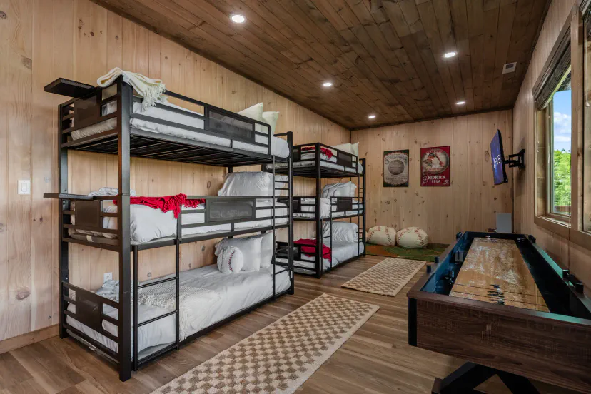 Cozy bunk room with triple bunks, TV, and games for the whole group