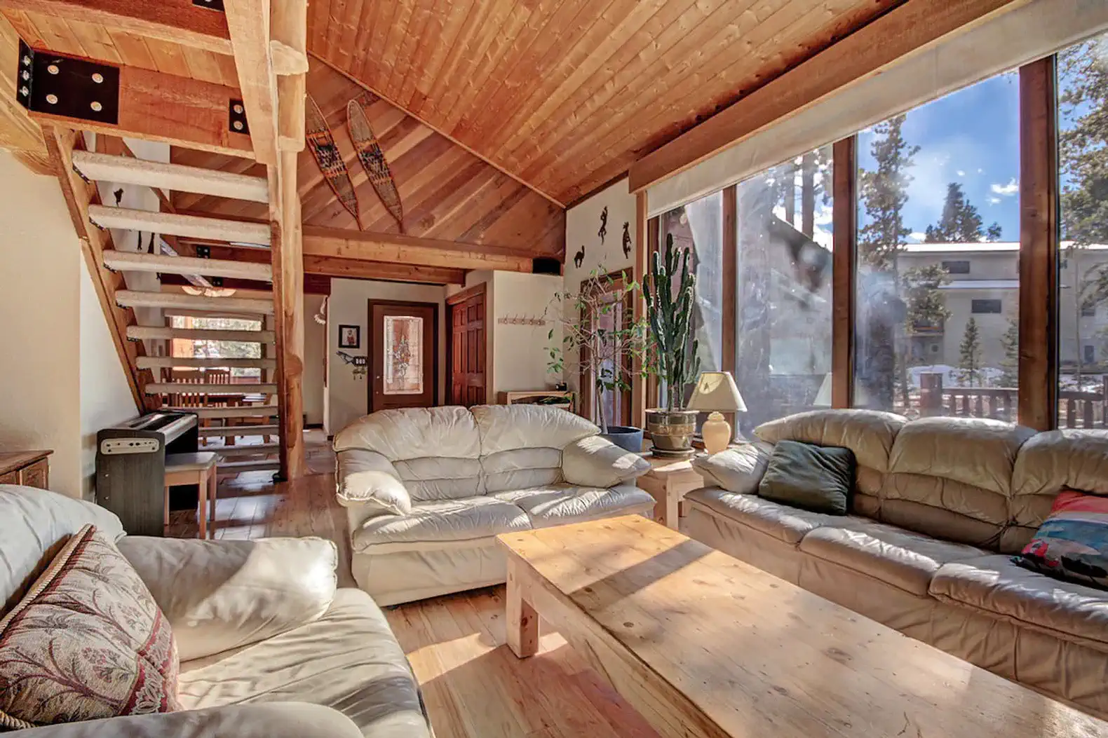 Spacious living room with large windows and wooden ceiling