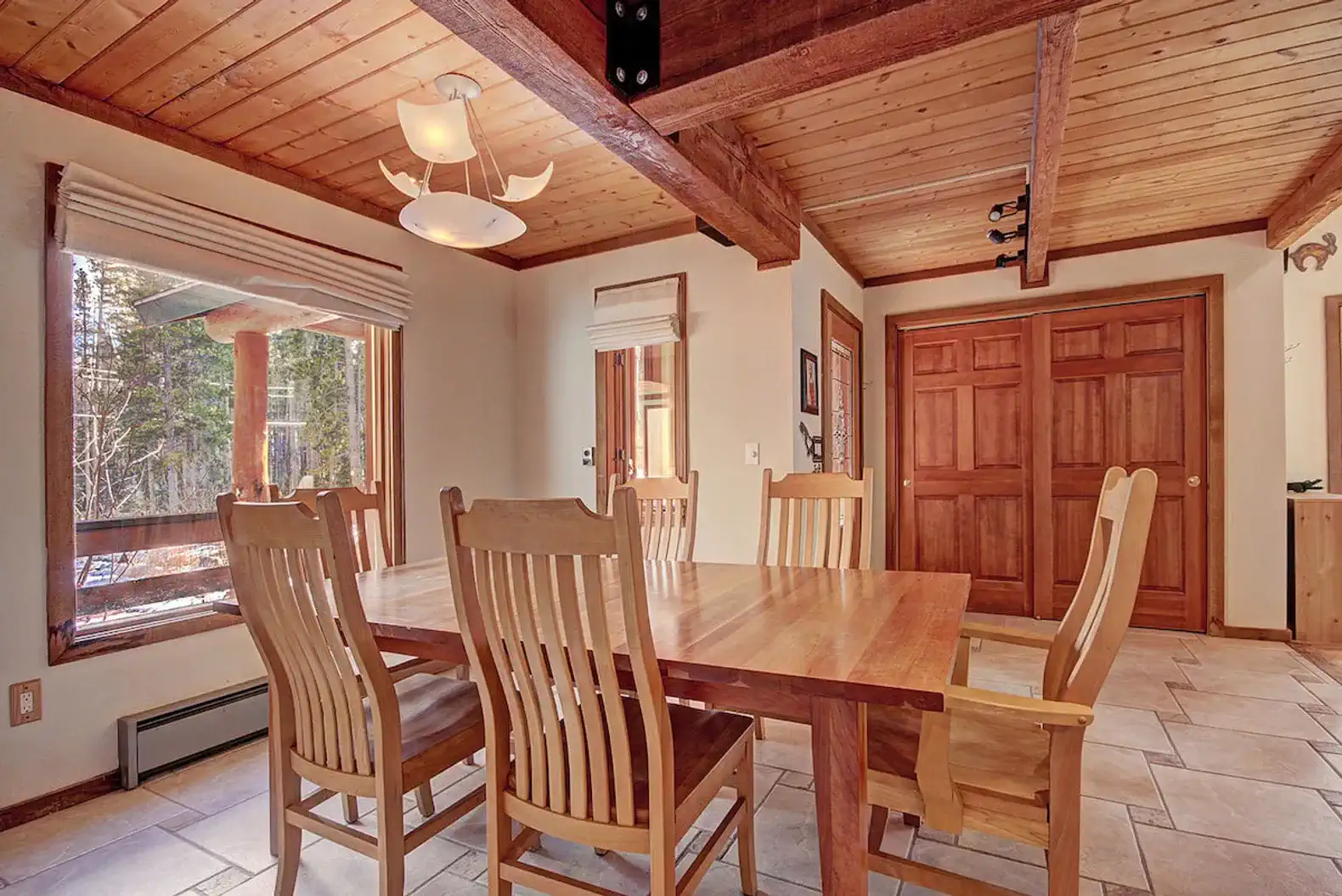 Spacious dining area with wooden table and chairs, large windows for natural light