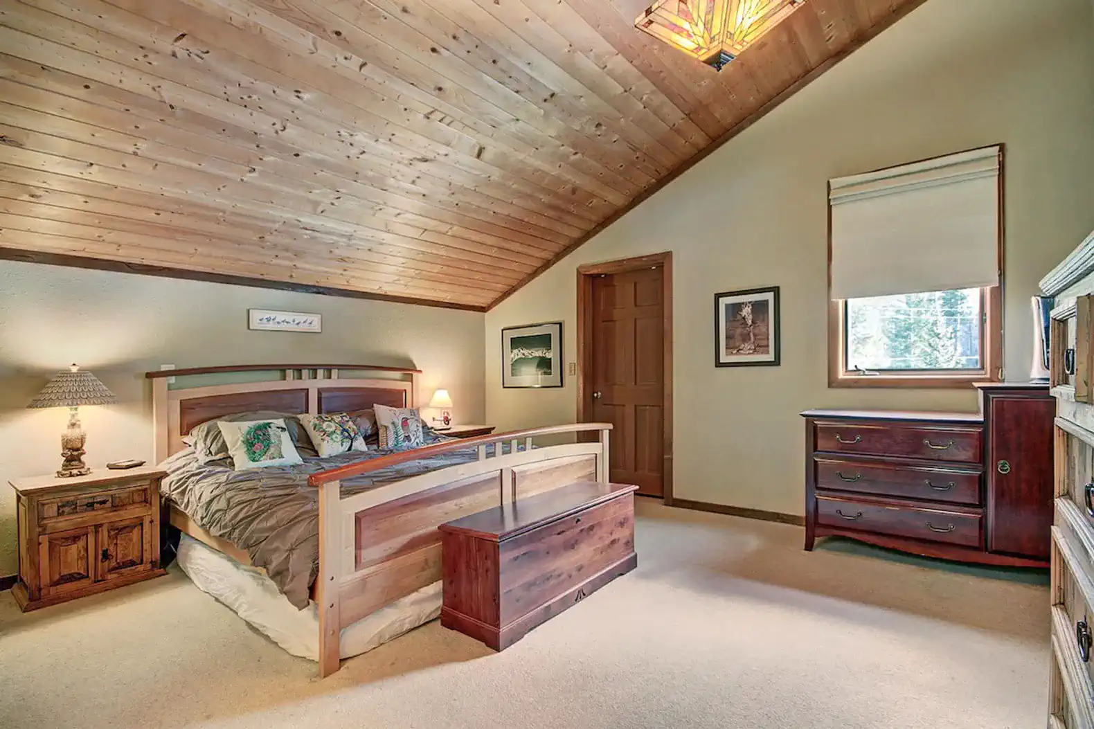Cozy master bedroom with wooden ceiling and warm decor