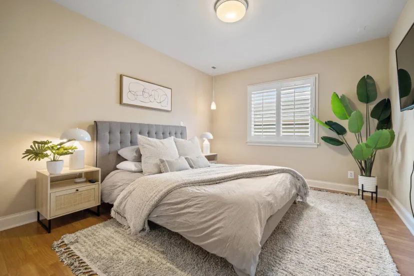 Gemütliches Hauptschlafzimmer mit einem weichen Bett, dekorativen Pflanzen und natürlichem Licht