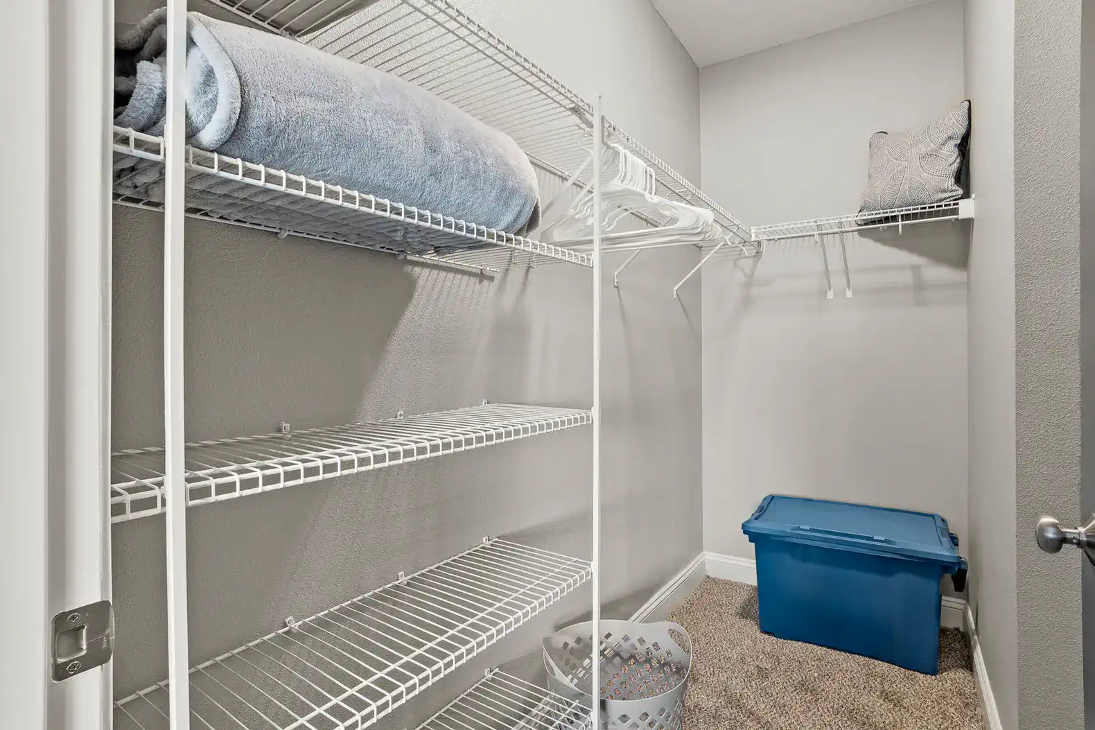 Spacious walk-in closet with shelves, hangers & extra linens