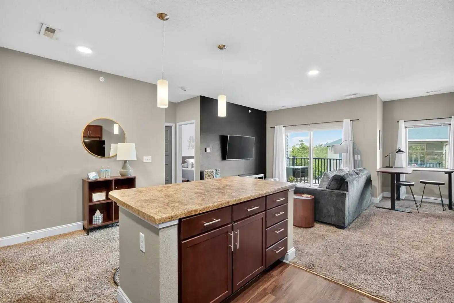 Step inside to an open-concept design with a full kitchen, spacious island, and modern pendant lighting. The island overlooks the living room and balcony, blending cooking, dining, and relaxing in one seamless space.