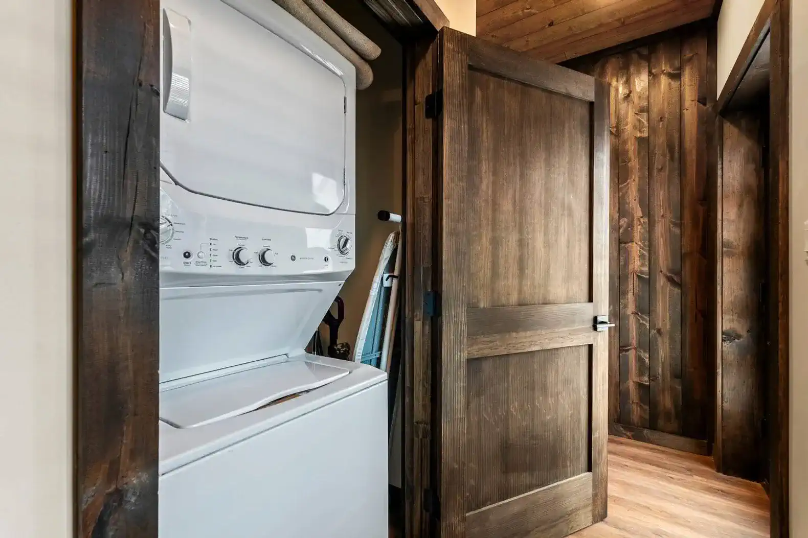 Washer and dryer in a cozy laundry room with wooden accents