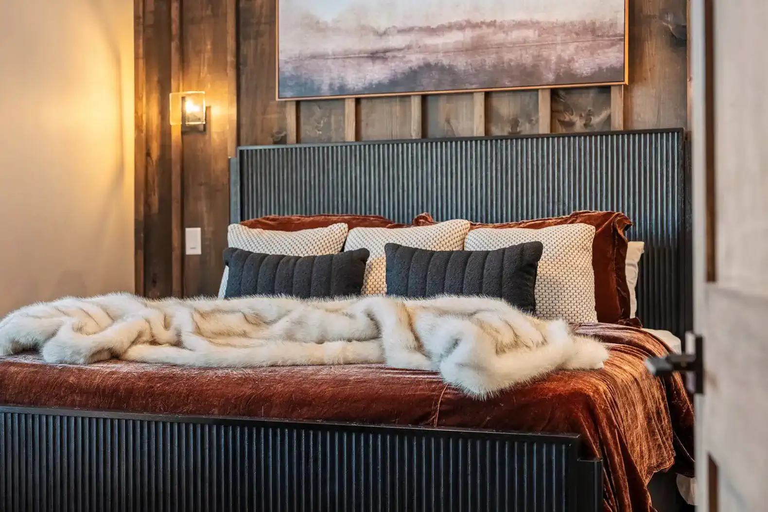 Cozy master bedroom with a plush bed, decorative pillows, and warm wood accents