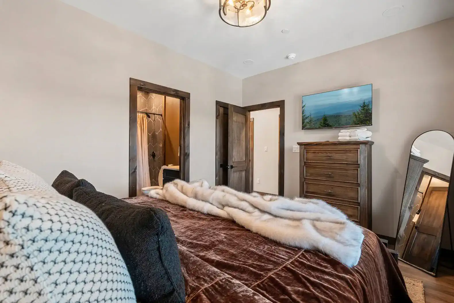 Cozy master bedroom with plush bedding and wooden furniture