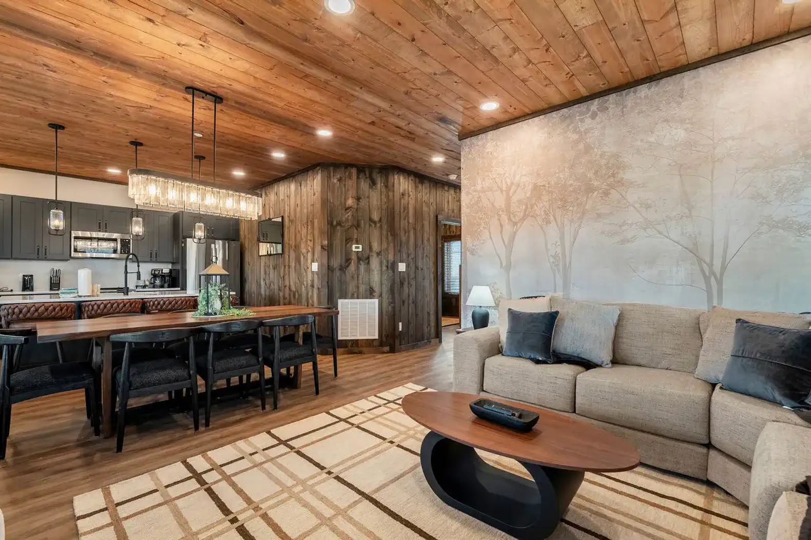Spacious living area with wooden ceiling, cozy sofa, and dining table