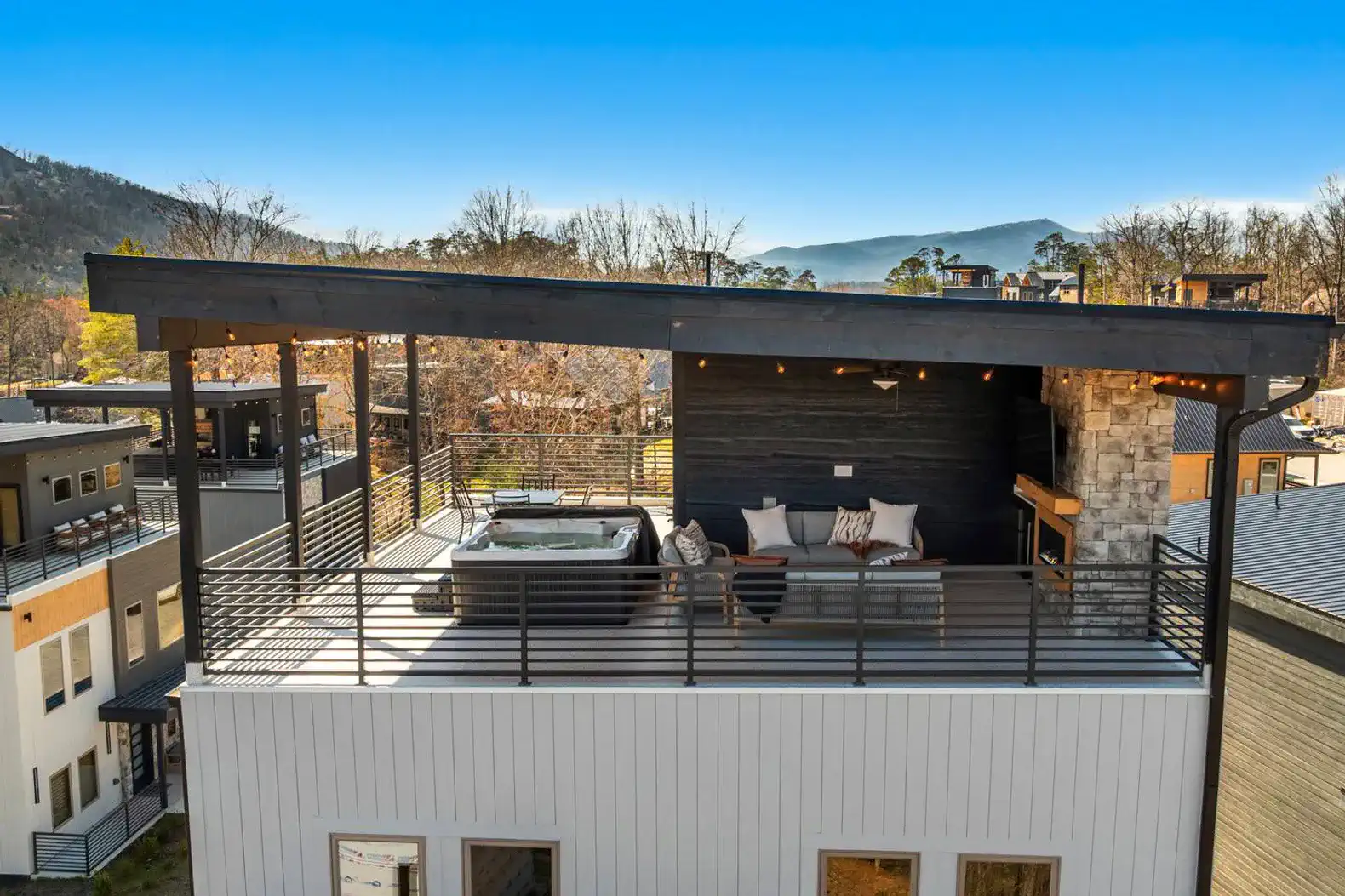 Rooftop deck with hot tub and seating area overlooking mountains