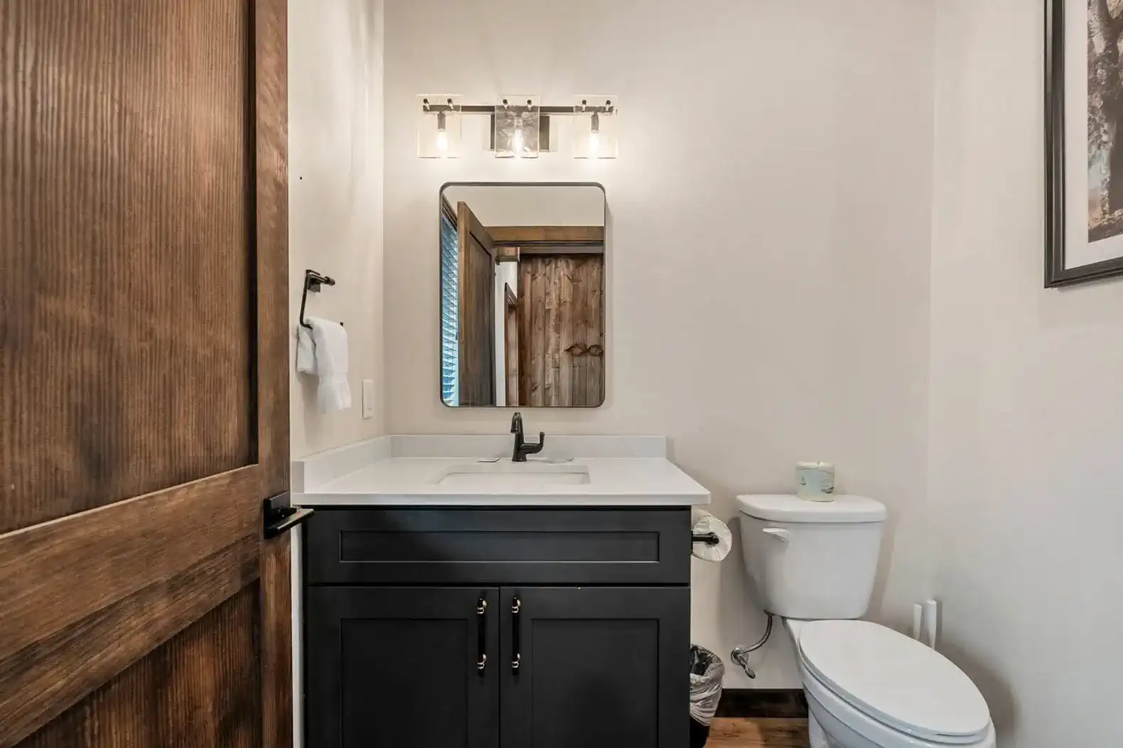 Modern bathroom with dark cabinetry and a large mirror