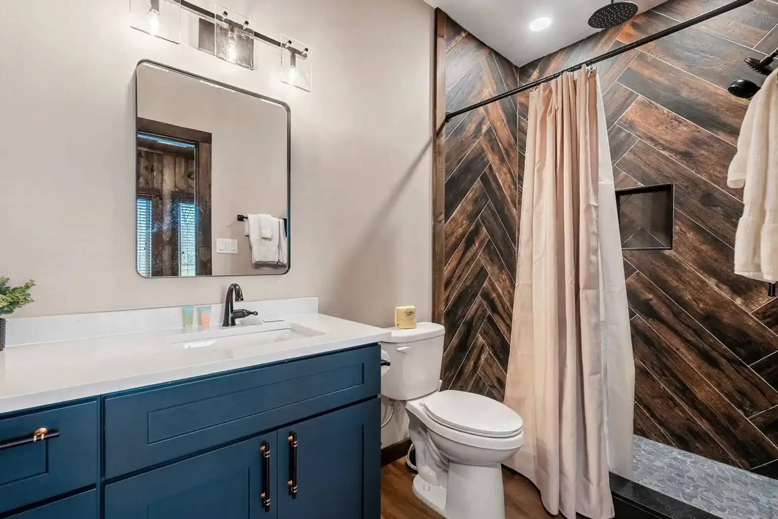 Modern bathroom featuring a stylish shower and blue cabinetry