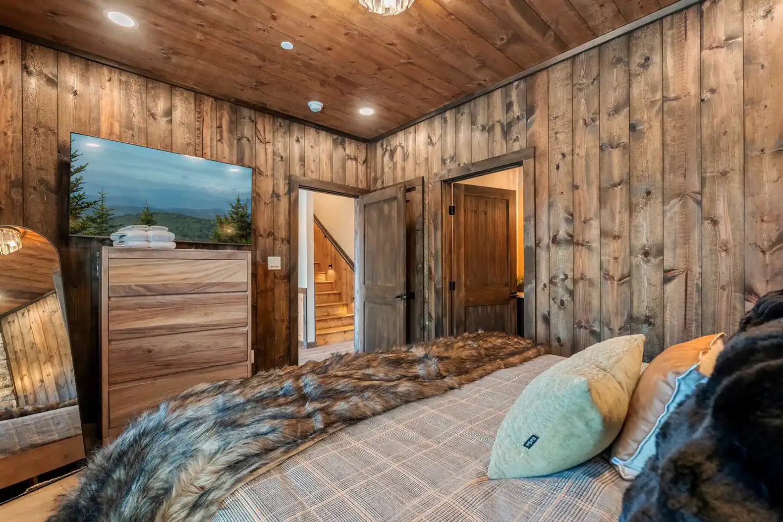 Cozy bedroom with wooden walls and a plush bed