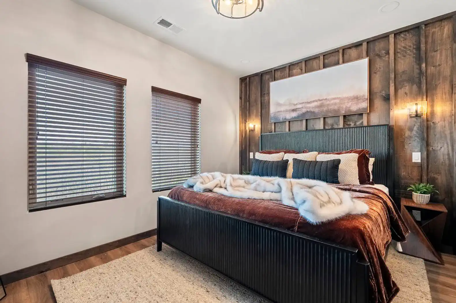 Cozy master bedroom with wooden accents and large windows