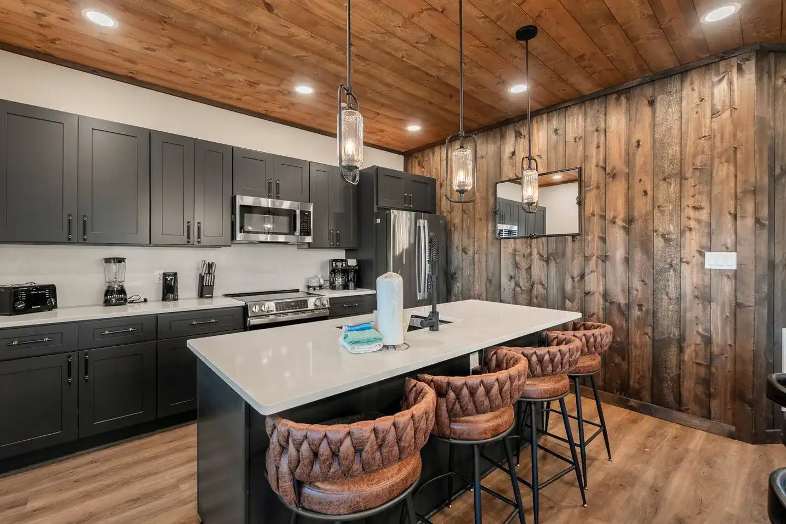 Modern kitchen with dark cabinets, stainless steel appliances, and a large island with seating