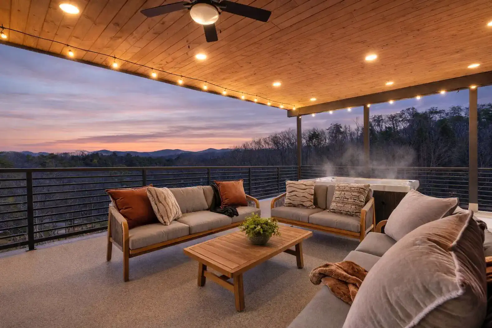 Spacious outdoor seating area with hot tub and sunset view