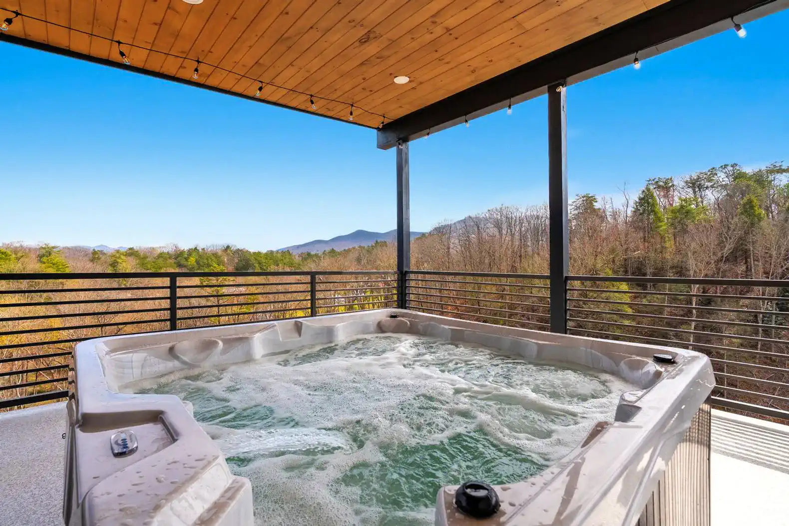 Hot tub with a scenic mountain view on a rooftop deck