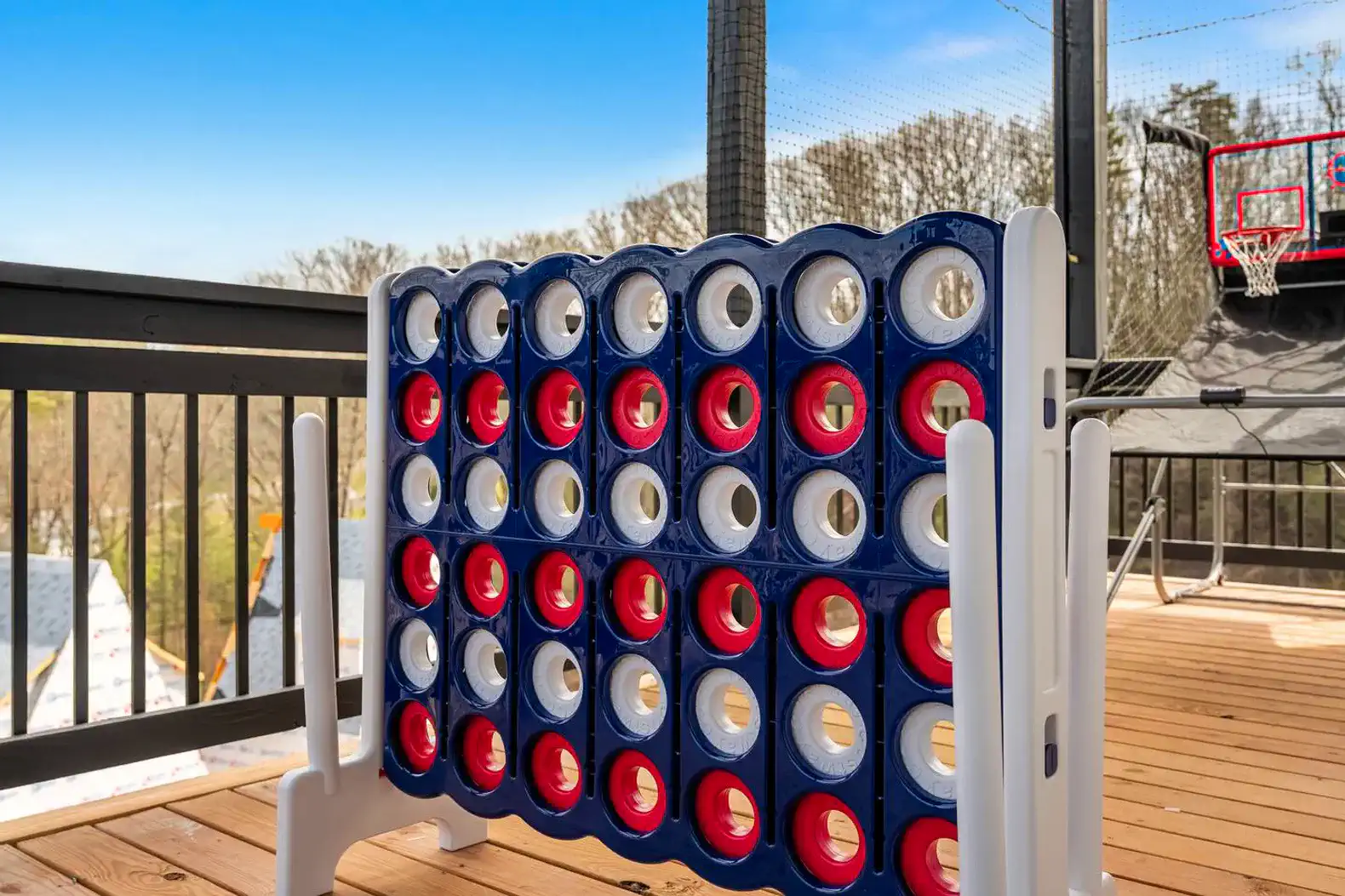 Outdoor game area featuring a large Connect Four game on a wooden deck