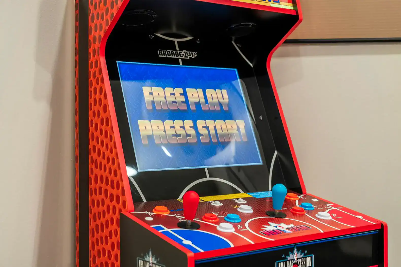 Arcade game machine with colorful controls and a screen displaying 'Free Play Press Start'