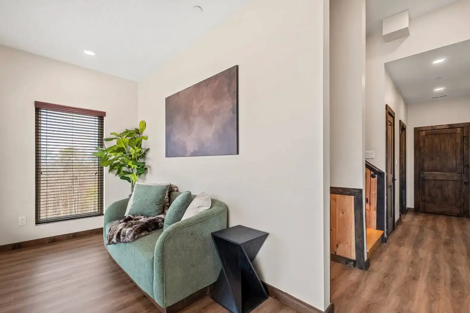 Cozy seating area with a green sofa and artwork on the wall