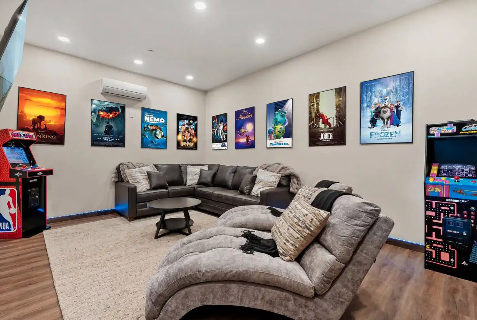 Cozy game room with large sectional sofa and movie posters on the walls