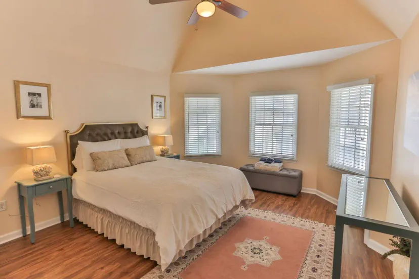 Habitación acogedora con una cama queen, luz natural de las ventanas de bahía y decoración elegante con una paleta de colores suaves
