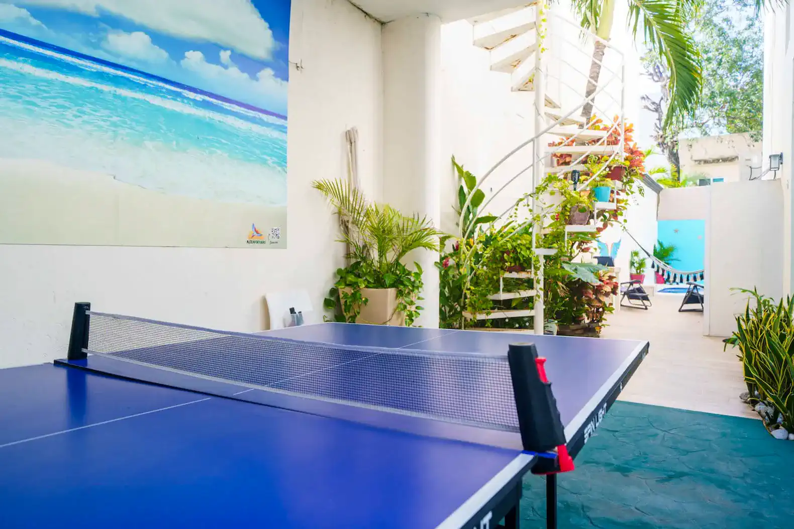 Outdoor area with a ping pong table and tropical plants