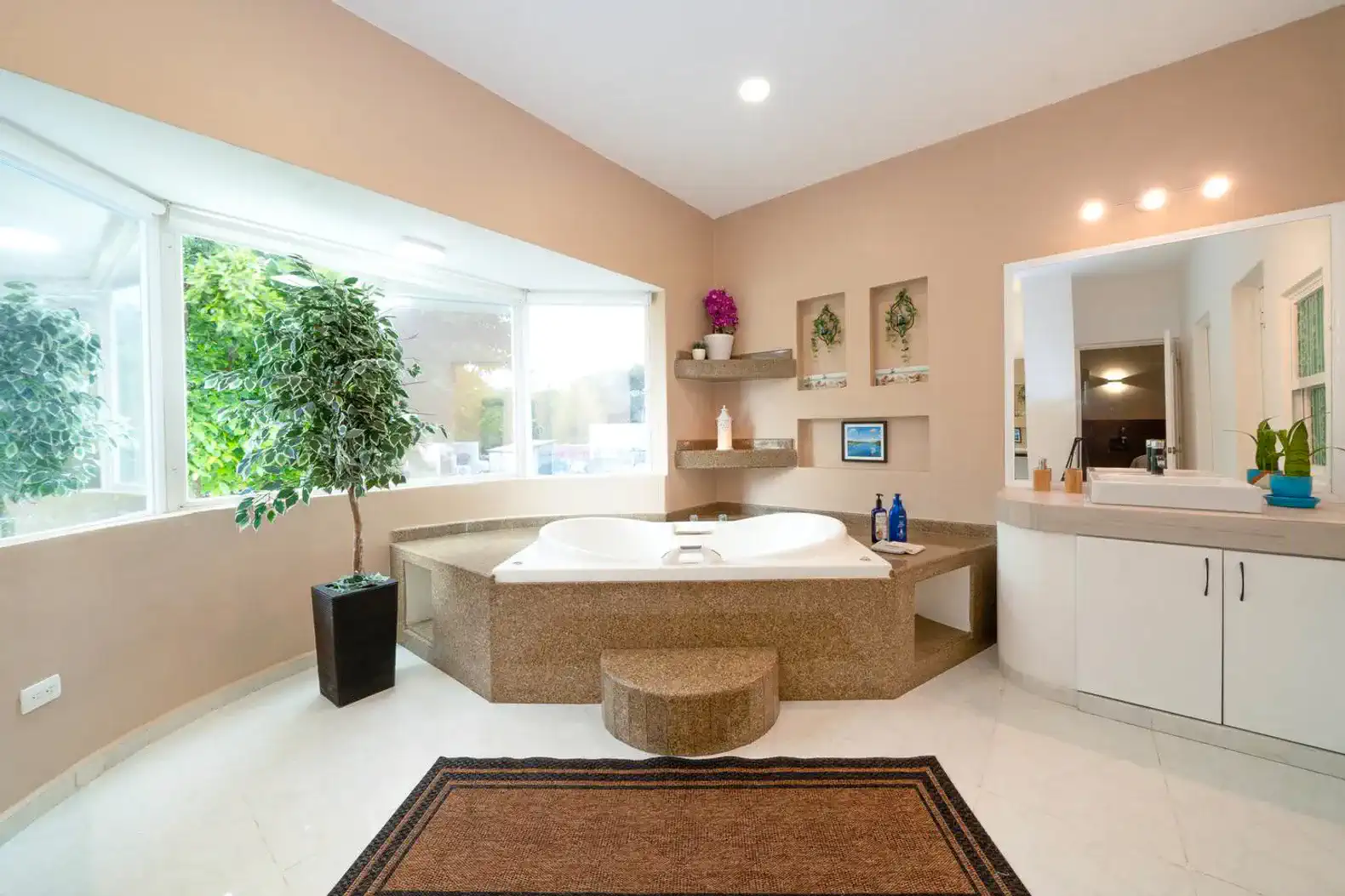 Spacious bathroom featuring a large soaking tub and natural light from windows